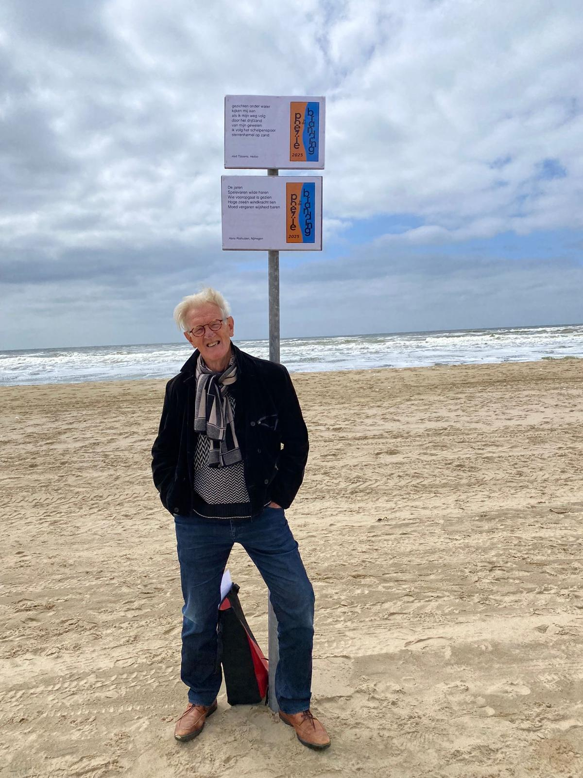 Aad Tijssens op het strand bij een poëziebord